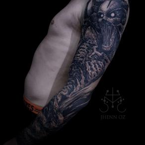 Tatouage dark sur tout le bras réalisé par Jhenn Oz
