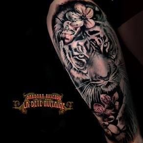 Portrait réaliste de tigre assorti de fleurs tatoué par Barbara Rosendo