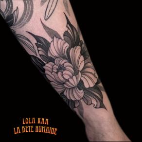 Fleur tatouée en freehand noir et gris sur l’avant-bras par Lola Kaa