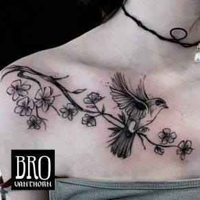 Petit oiseau battant des ailes sur une branche, tatoué par Bro Vanthorn