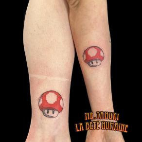 Duo de champignons issus des jeux vidéo Mario, tatoué par Peter Galt
