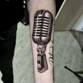 Microphone vintage réaliste tatoué sur bras par Jérémy Fatneedle