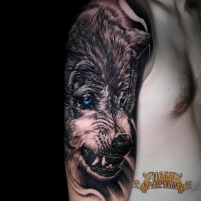 Portrait réaliste de loup aux yeux bleus tatoué par Moka