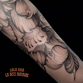 Gros plan sur un tatouage floral en noir et gris réalisé par Lola Kaa